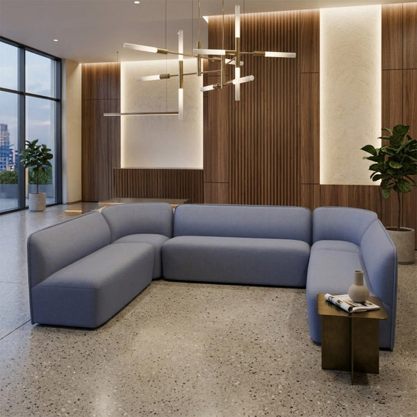 Light blue sectional sofa with a smooth, modern fabric, set against a warm wood and neutral backdrop.