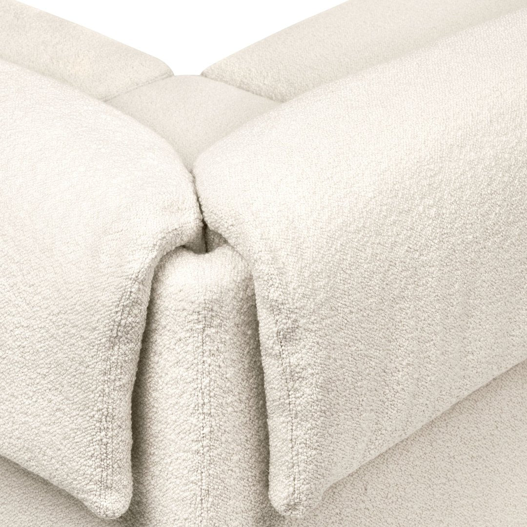 Soft, plush cream fabric with a textured pattern, perfect for cozy interiors.