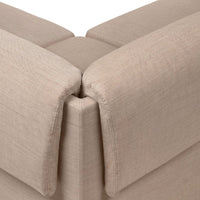 Beige sectional sofa corner with a textured fabric finish, showcasing a soft, neutral color palette.