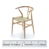 Natural wood chair with a minimalist design and woven seat, featuring smooth lines and a light finish.