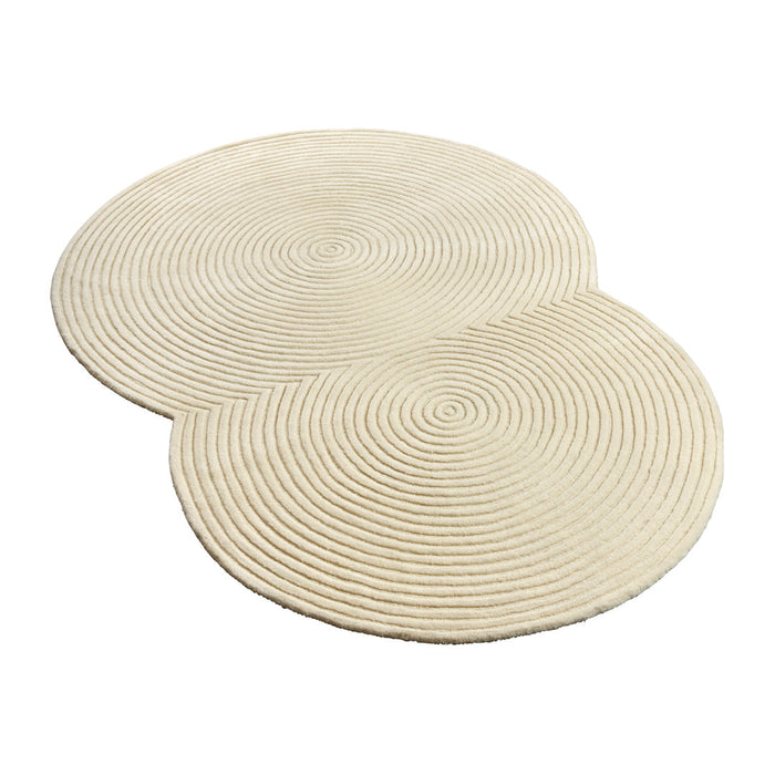 Cream-colored circular rug with textured spiral pattern, adding a modern touch to any space.
