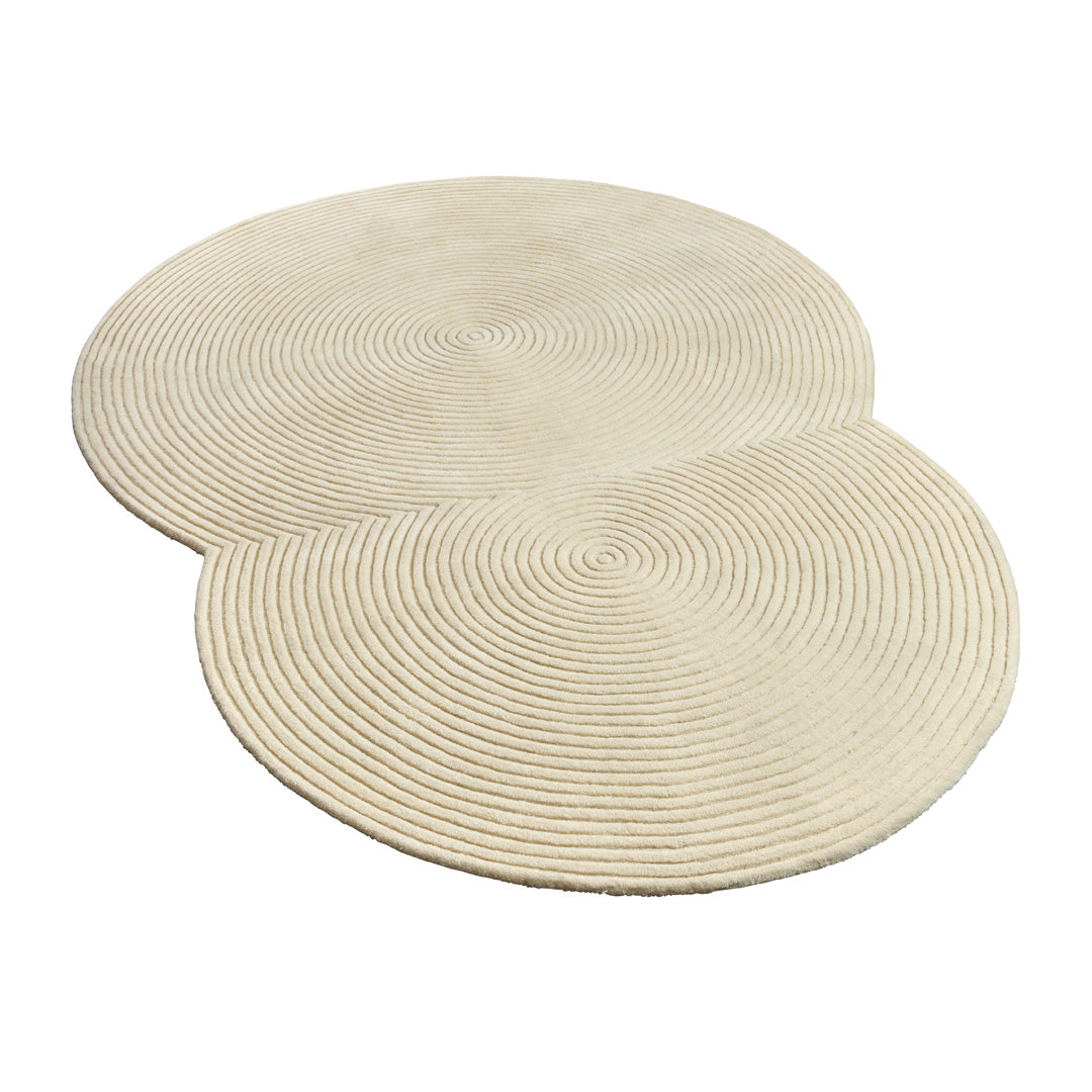 Beige circular rug with textured spiral pattern, featuring two overlapping circles for a modern design accent.