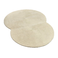 Beige circular rug with textured spiral pattern, featuring two overlapping circles for a modern design accent.