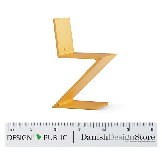 Yellow zigzag chair with a sleek, modern design, showcasing a vibrant solid color and minimalist pattern.