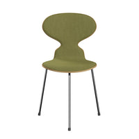 Green upholstered chair with a unique silhouette and black metal legs, featuring a smooth, minimalist design.