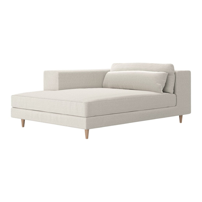 Soft beige chaise lounge with minimalist design and light wooden legs, featuring smooth, textured upholstery.