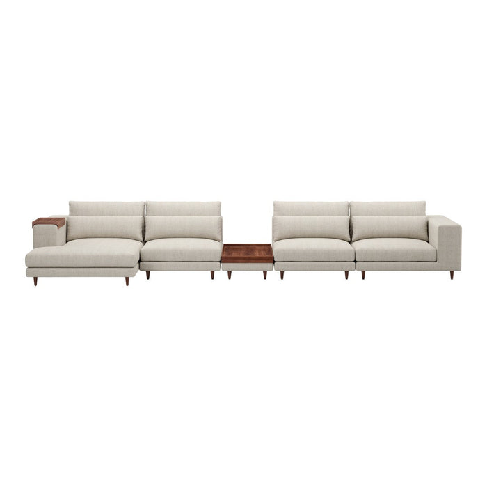 Light beige sectional sofa with plush cushions and a sleek wooden table accent. Modern, minimalist design.