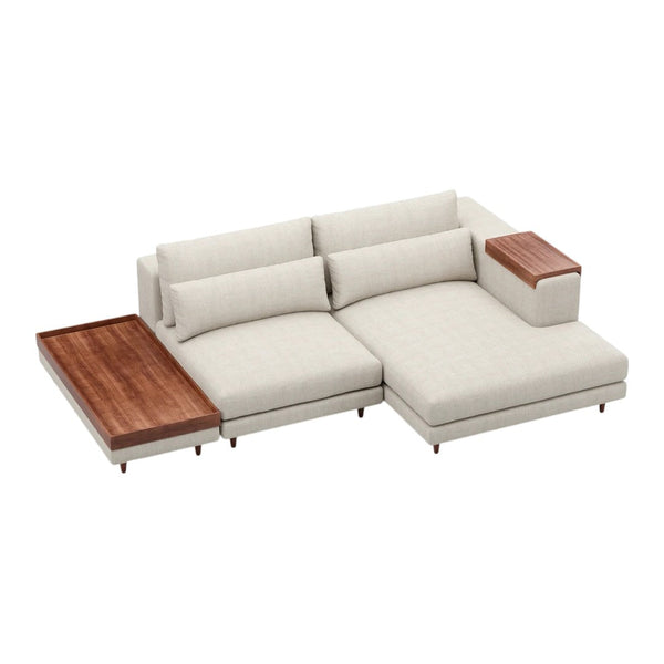 Light beige sectional sofa with a wooden side table and a rich brown wood accent. Simple, modern design.