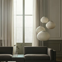 Soft beige curtains paired with minimalist, cream-colored pendant lights in a stylish modern living room.