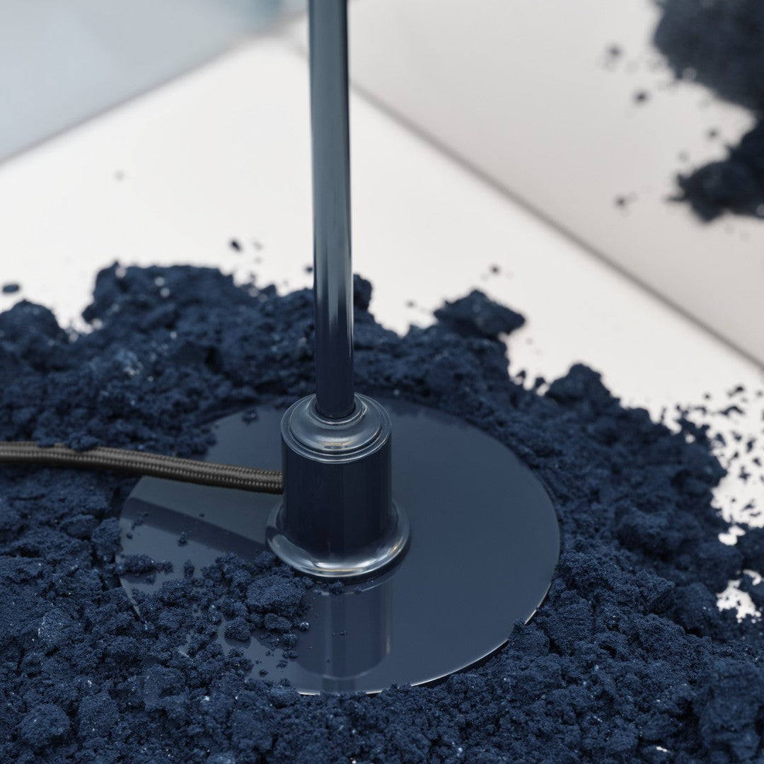 Navy blue base with a glossy finish, surrounded by a textured dark blue powder for a modern aesthetic.