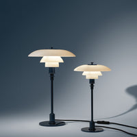 Two stylish lamps featuring layered white shades and sleek black bases against a subtle gradient background.