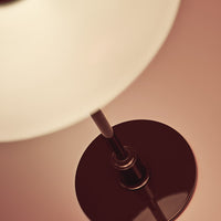 Modern lamp with a glossy brown base and soft white glass shade, creating a stylish and warm light effect.