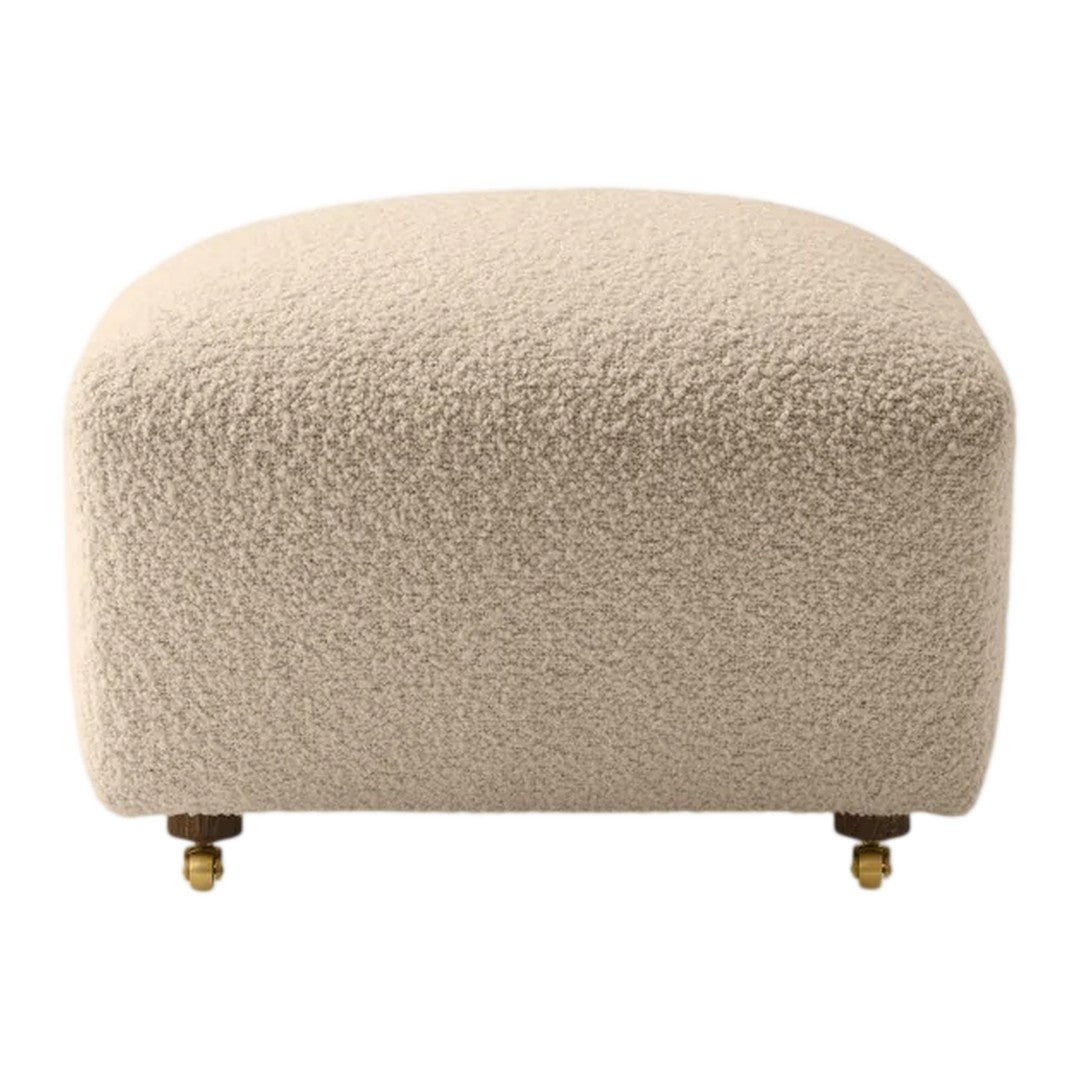 Beige boucle ottoman with a textured surface and gold caster legs, perfect for modern decor.