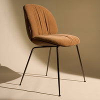 Brown upholstered chair with vertical ribbed pattern and sleek black metal legs, set against a neutral background.
