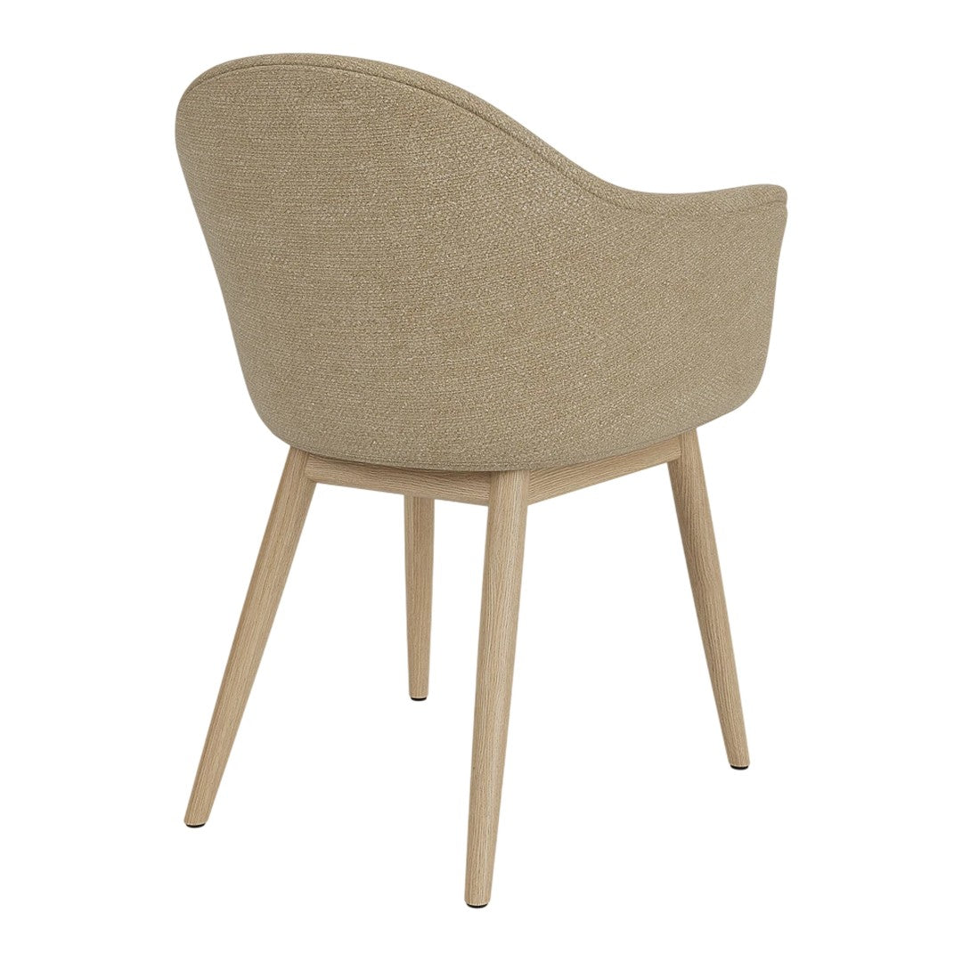 Beige upholstered chair with curved back and natural wood legs, featuring a subtle textured pattern.