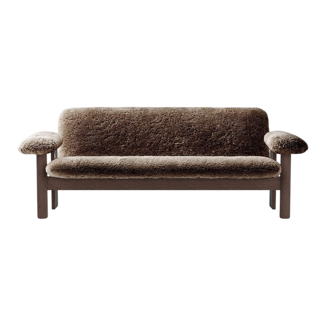 Brown upholstered sofa with soft, textured fabric and wooden frame, featuring a minimalistic design.