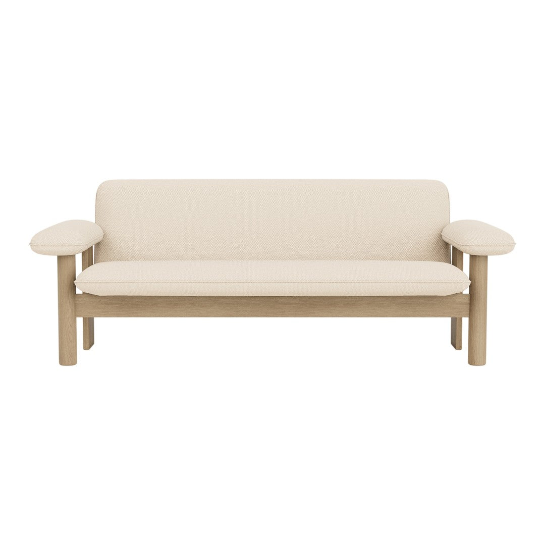 Minimalist cream sofa with light wooden arms, featuring a sleek, solid design and no visible patterns.