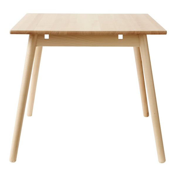 Light wood dining table with a clean, minimalist design and natural finish, showcasing smooth grain patterns.