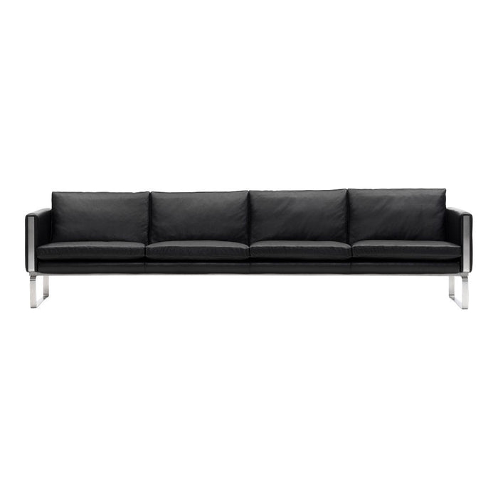 Black leather sofa with a sleek, minimalist design and four cushioned seats, featuring a chrome frame for modern elegance.