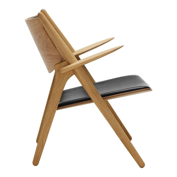 Side view of a modern chair featuring a light oak frame and sleek black seat, showcasing minimalist design and natural wood grain.