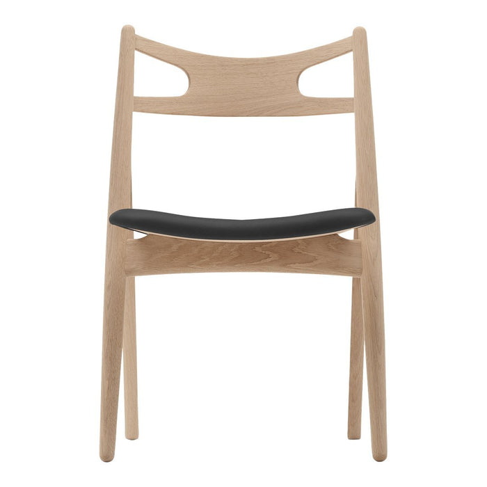 Light wood chair with a minimalist design featuring a black upholstered seat and smooth natural finish.