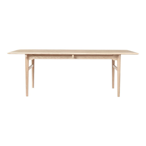 Light oak dining table with a smooth, natural finish and minimalist design for a modern aesthetic.