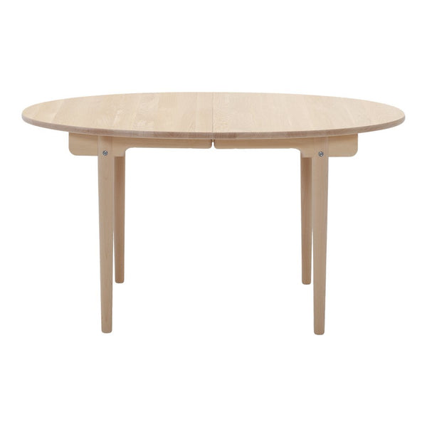 Natural wood round dining table with a smooth finish and minimalist design. Light beige color enhances any decor.