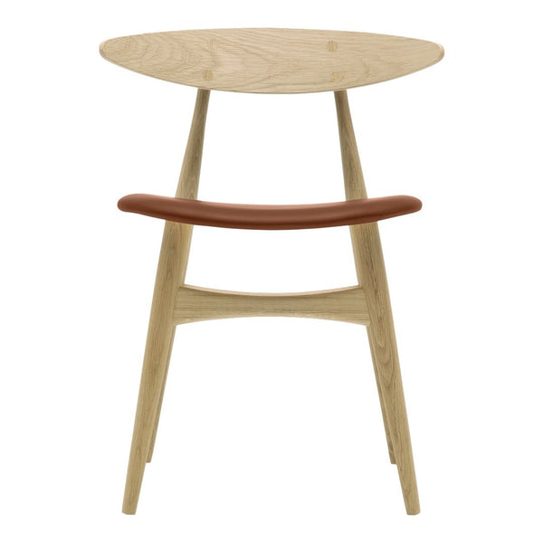 Light wood chair with a smooth, circular top and a curved brown leather accent, showcasing minimalist design.