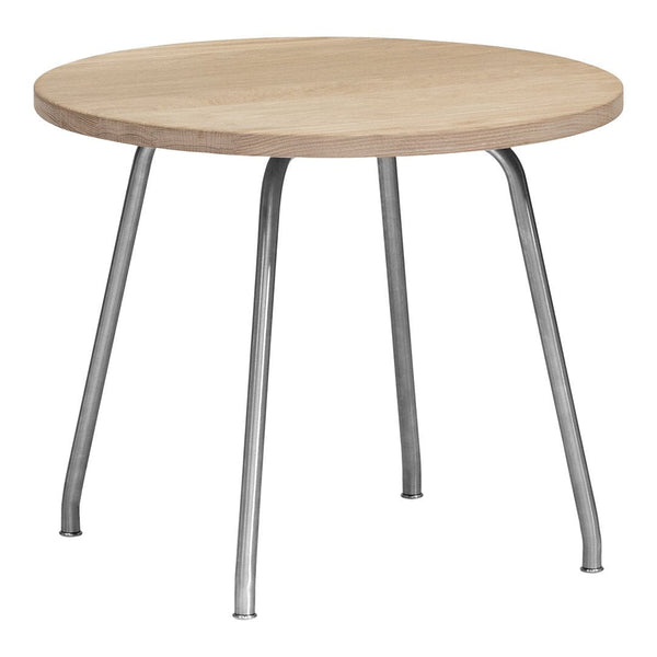 Round wooden table with a light oak surface and sleek silver legs, featuring a minimalist design.