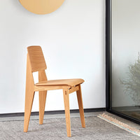 Natural wood chair with a sleek, minimalist design and a warm, light oak finish against a neutral backdrop.