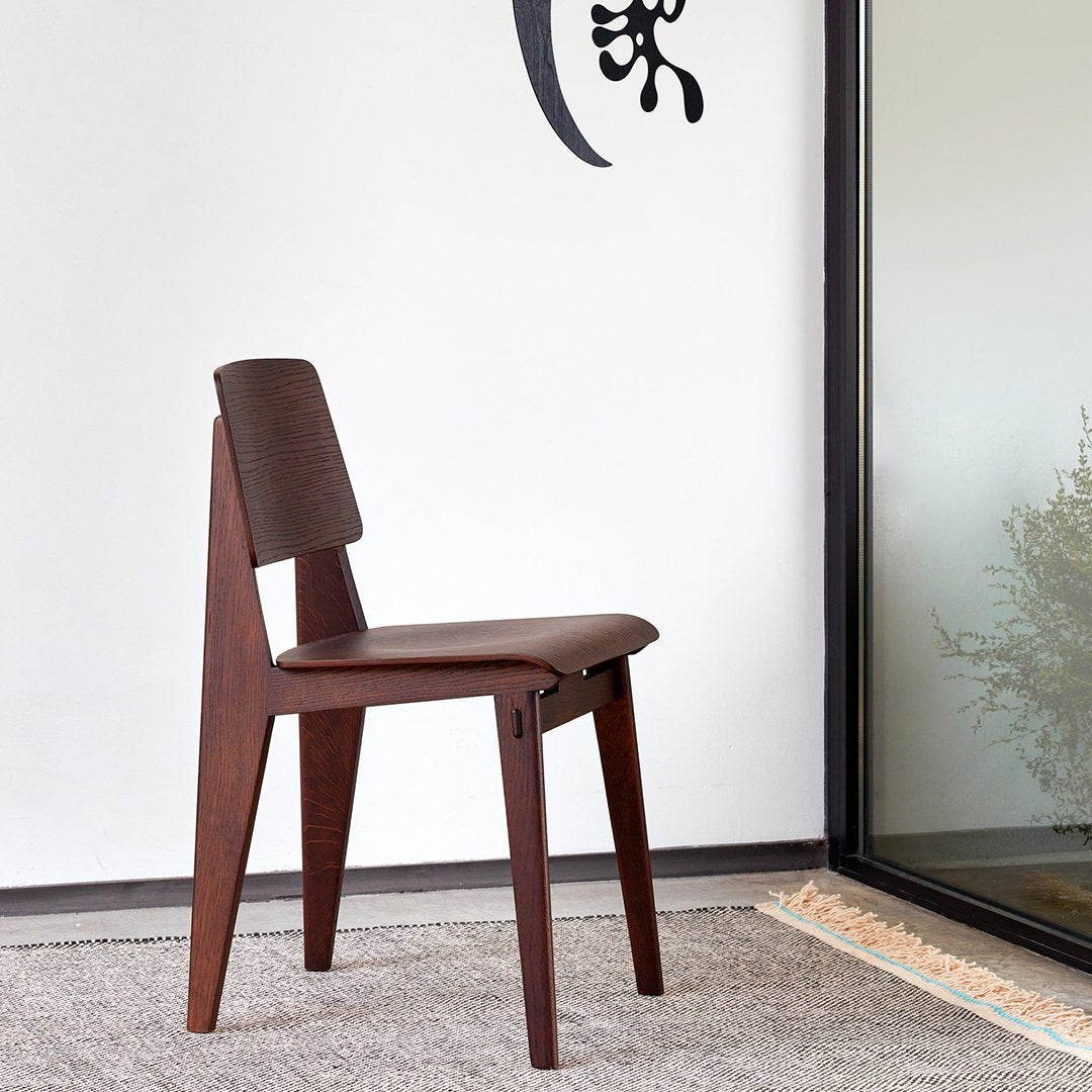 Brown wooden chair with a sleek design, featuring a smooth, dark finish and minimalist lines against a neutral background.