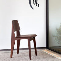 Brown wooden chair with a sleek design, featuring a smooth, dark finish and minimalist lines against a neutral background.