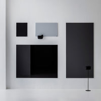 Assorted black and gray wall panels with sleek, modern design and minimalistic patterns against a white background.