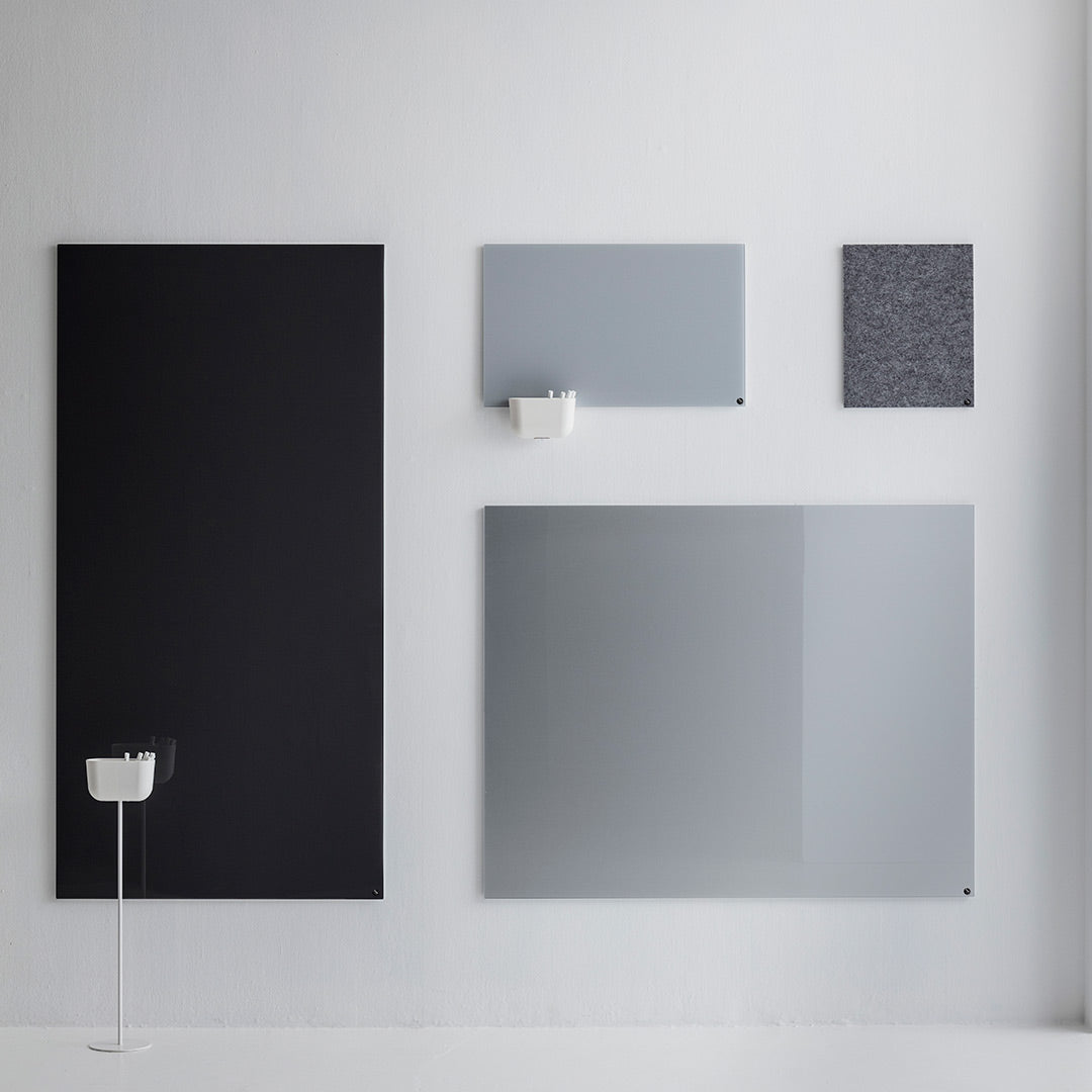 Contemporary wall art display featuring black, gray, and textured patterns in various shapes and sizes.