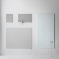 "Collection of gray wall panels with textured and smooth finishes, featuring various shapes and sizes against a pale backdrop."