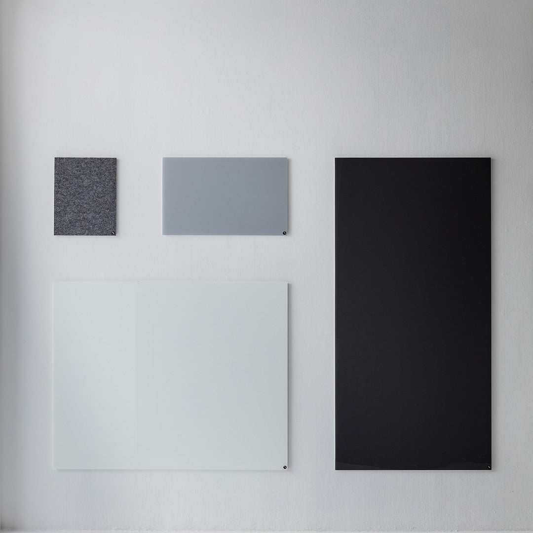 Four minimalist panels in varying shades of gray, black, and white, featuring textured and smooth surfaces.