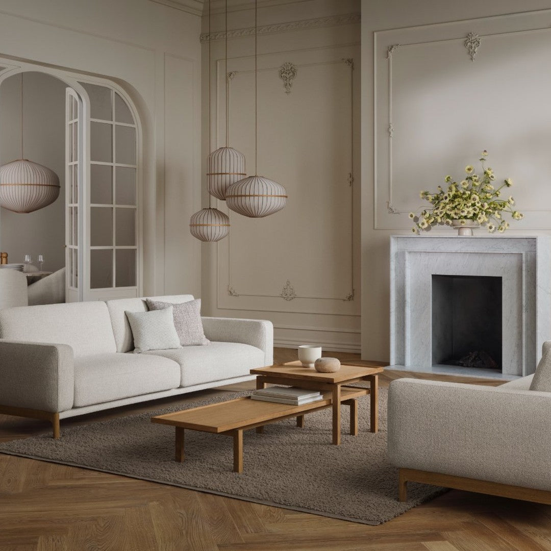 Neutral-toned living room featuring soft white sofas, wood accents, and elegant hanging lanterns in a sleek design.