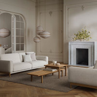 Neutral-toned living room featuring soft white sofas, wood accents, and elegant hanging lanterns in a sleek design.