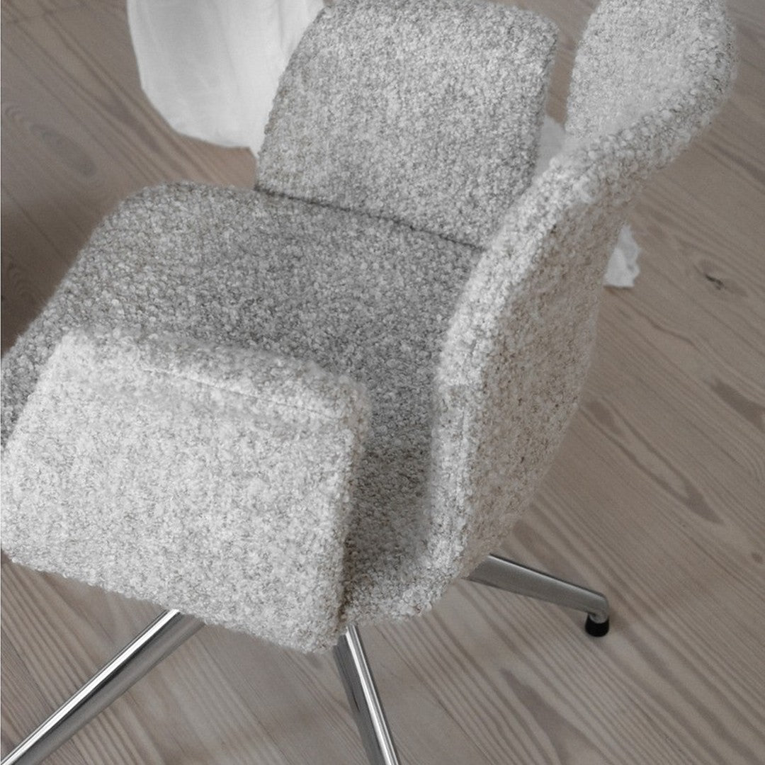 Soft gray textured upholstery on a modern chair, featuring a sleek, minimalist design. Silver chrome base.