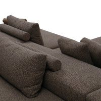 Textured brown sofa with various patterned cushions, featuring neutral tones for a modern aesthetic.