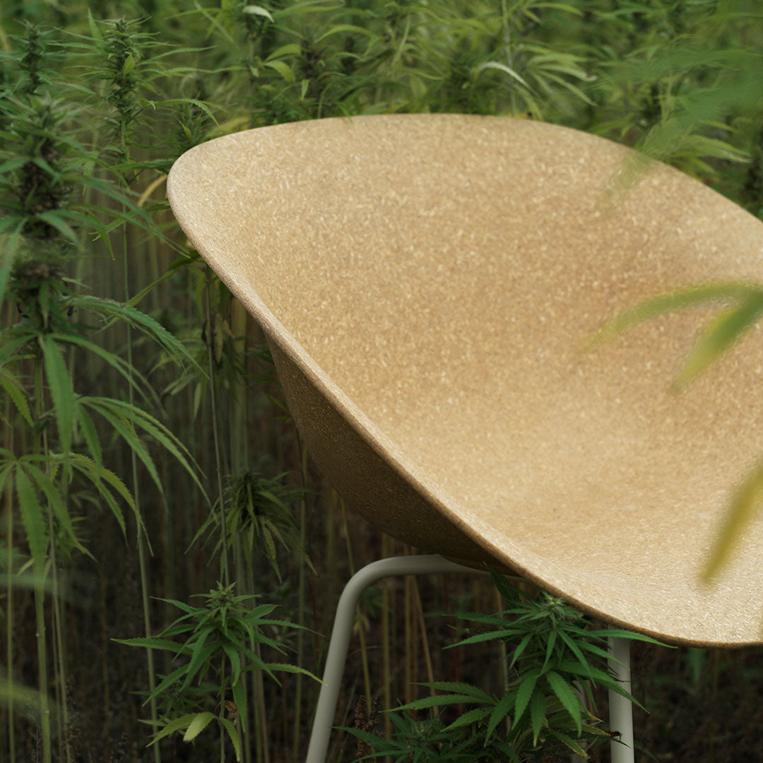 "Golden speckled bowl chair against a backdrop of lush green plants."