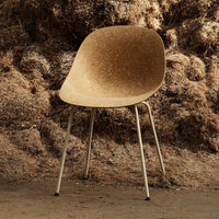 Cork-colored chair with a smooth, organic shape and metallic legs, set against a textured brown backdrop.