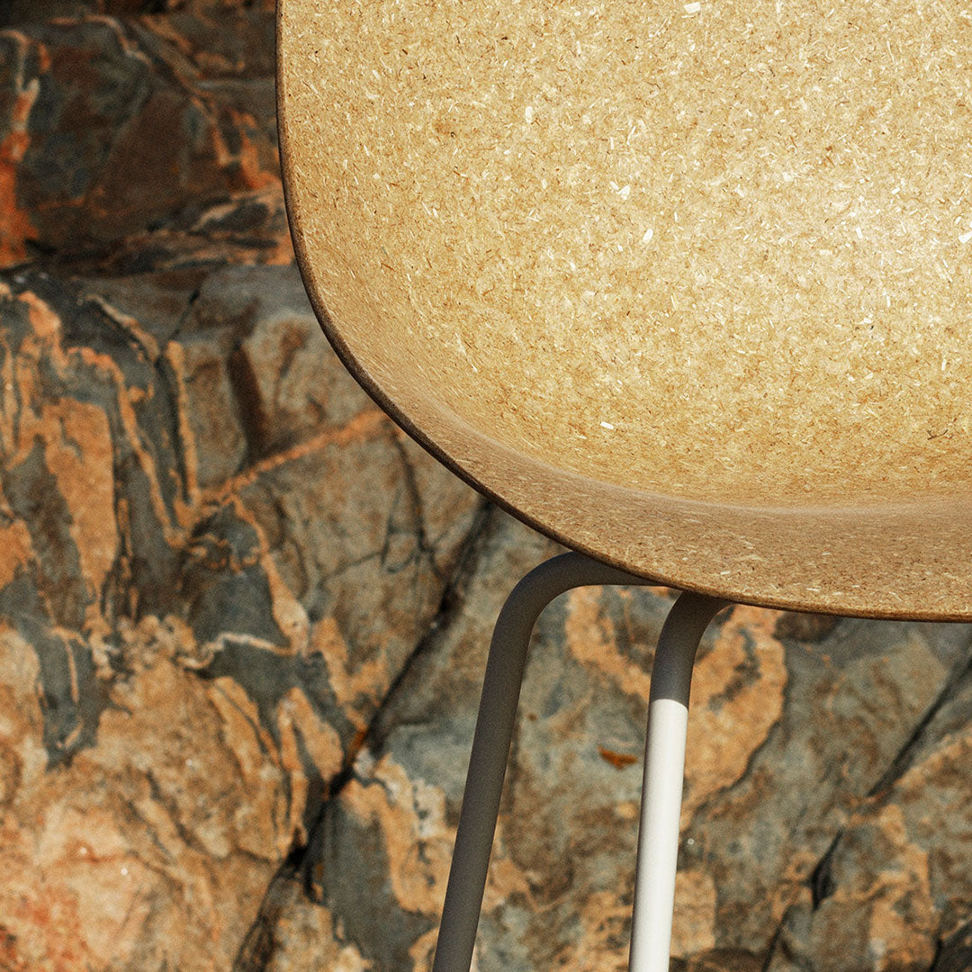 Gold speckled bowl with a sleek gray and white stand against a textured stone background. Ideal for modern decor.