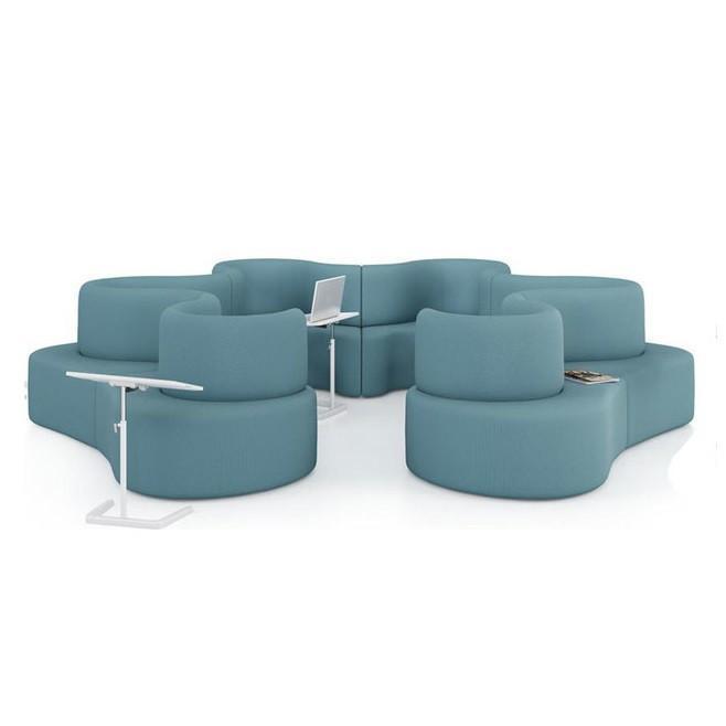 Curvy lounge seating in soft teal fabric with minimalist white table accents.