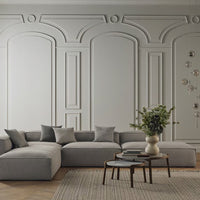 Gray sectional sofa with textured cushions against a soft gray wall, paired with a neutral geometric rug and round table.