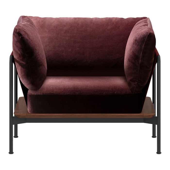 Plush burgundy velvet loveseat with rounded armrests and minimalistic black metal frame, featuring a wood shelf below.