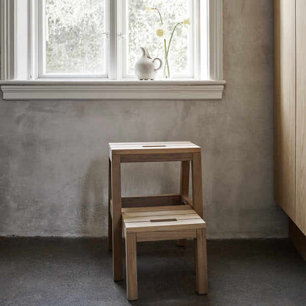 Natural wood stacking stools with a smooth finish, featuring light beige tones and subtle grain patterns.