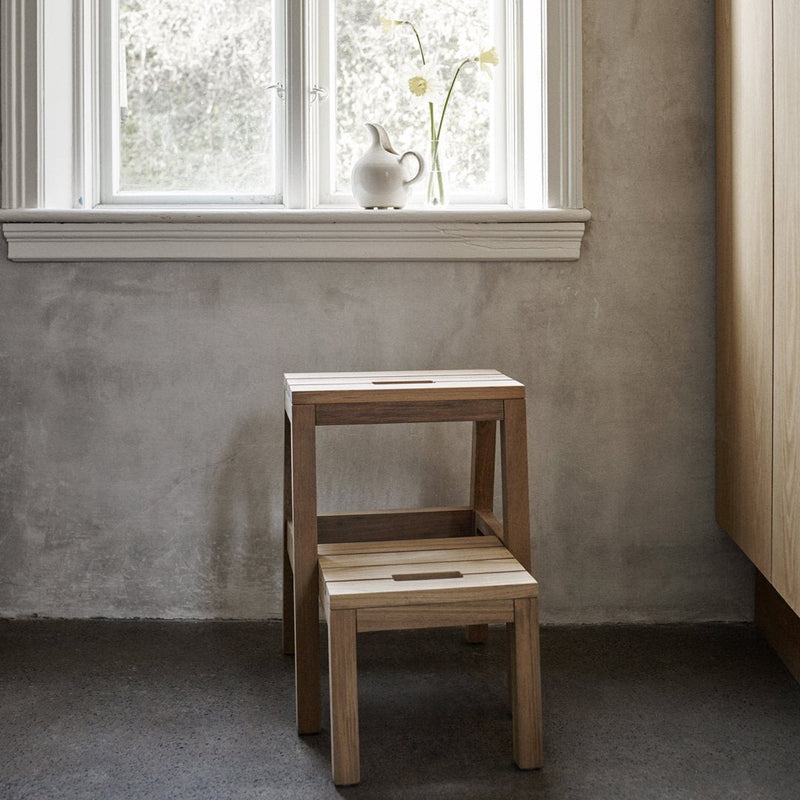 Natural wood stacking stools with a smooth finish, featuring light beige tones and subtle grain patterns.
