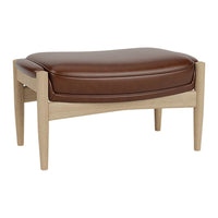 Brown leather ottoman with a soft curved design and light wood legs, featuring a minimalist pattern.