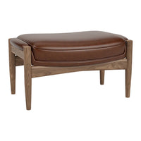 Brown leather ottoman with a smooth cushion atop a sleek walnut wood frame, featuring elegant curves and minimalist design.